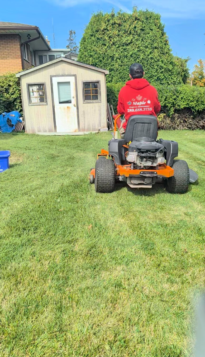 Maple Property Maintenance crew member on a zero-turn mower leaving clean lines in a backyard lawn